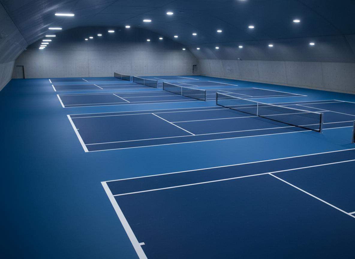 Indoor tennis court with uniform overhead sports lighting