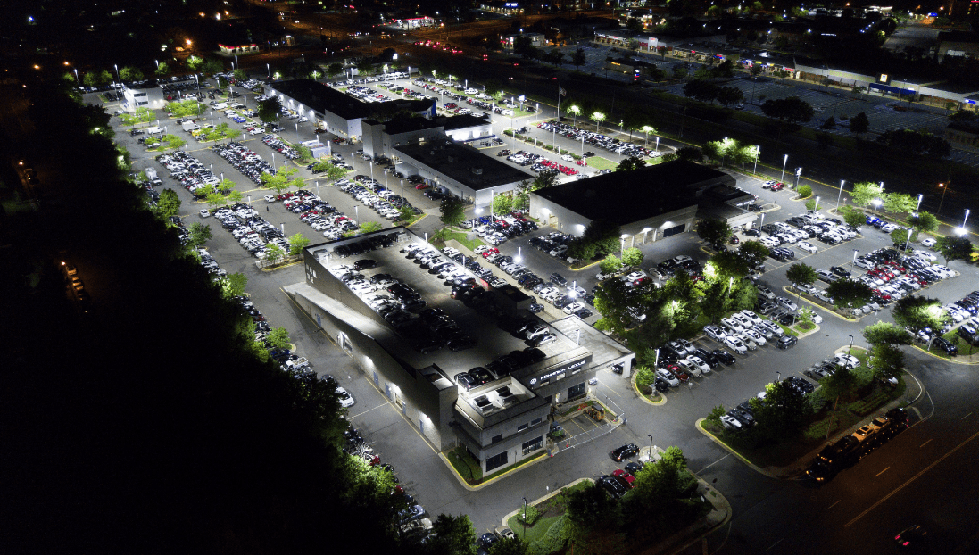Completed car dealership lighting installation at night showing illuminated vehicle display lots